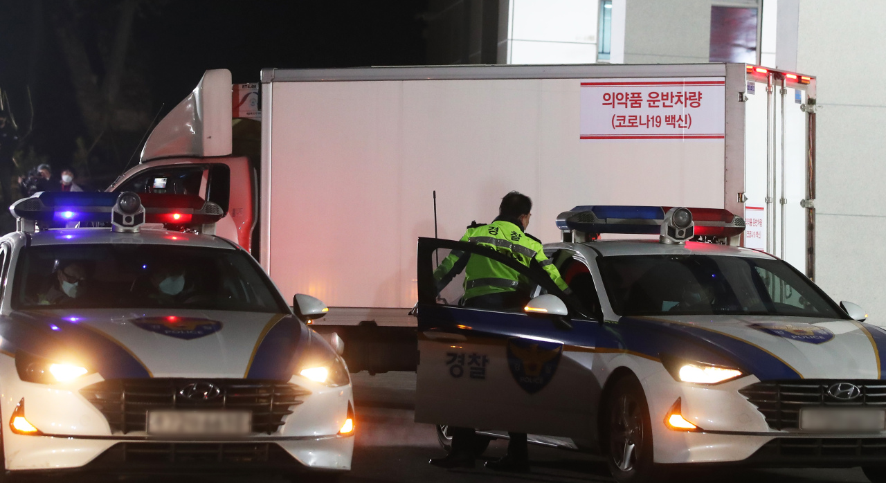 A truck carrying vials of AstraZeneca's vaccine departs from a cold chain logistics warehouse in Icheon, 80 km southeast of Seoul. under the strict guard of the Army and police on Thursday. (Yonhap)