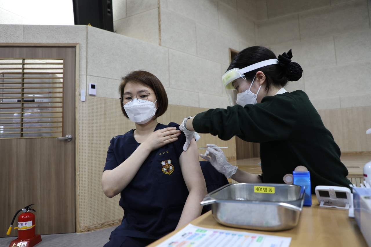 A military nurse is inoculated with a coronavirus vaccine at a military hospital, March 3, 2021. (Yonhap)