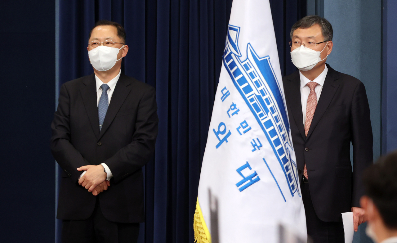 Kim Jin-kook (L), tapped as President Moon Jae-in's new senior secretary for civil affairs, and his predecessor Shin Hyun-soo meet reporters at the Chunchugwan press room of Cheong Wa Dae in Seoul on Thursday. (Yonhap)