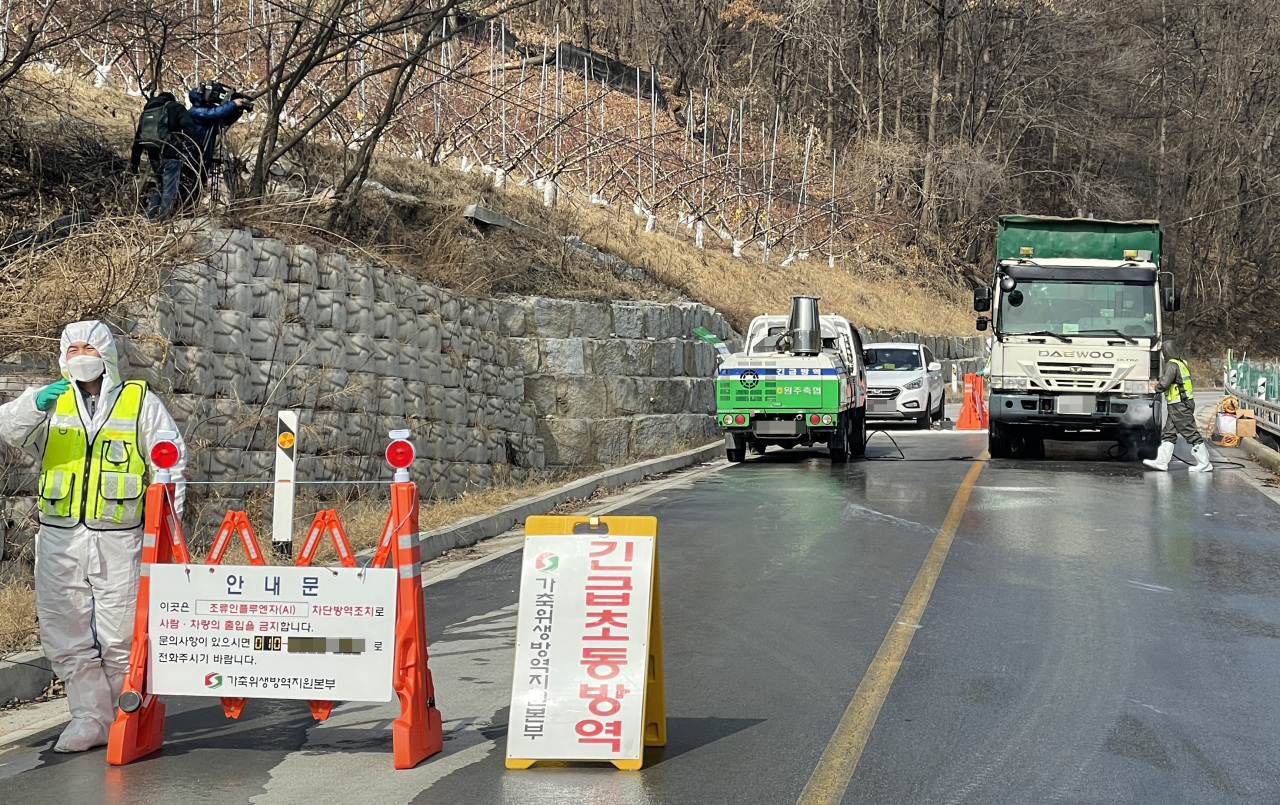 Officials carry out a disinfection operation on a road in Wonju, 132 kilometers east of Seoul, in this file photo taken on Feb. 24, 2021. (Yonhap)