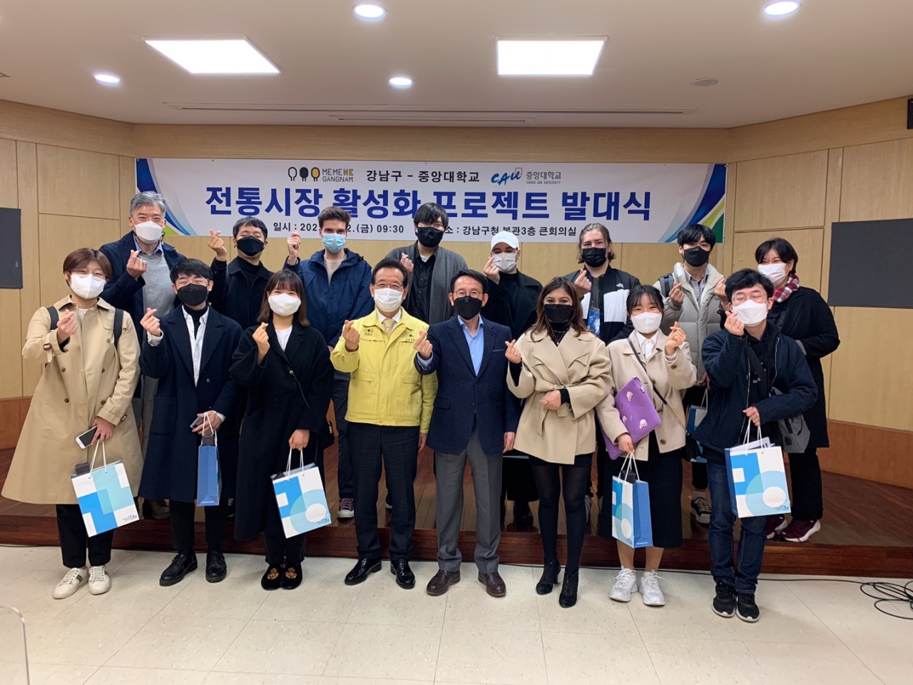 Jung Soon-kyun, mayor of Gangnam-gu (fourth from left), and Min Byoung-chul, a professor at Chung-Ang University (fifth from left), pose with students and lecturers who have joined a project to revitalize traditional markets at the Gangnam-gu Office in Seoul on Friday.