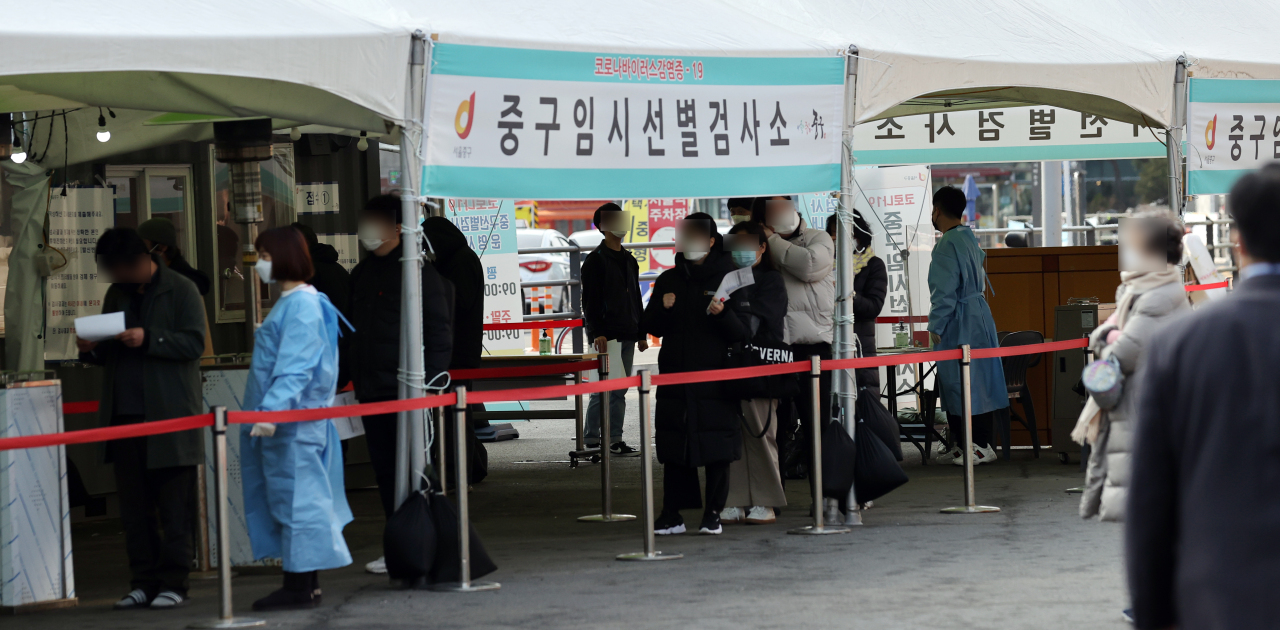 Citizens wait in line to receive new coronavirus tests at a temporary testing site set up in front of Seoul Station in central Seoul on March 7, 2021. (Yonhap)