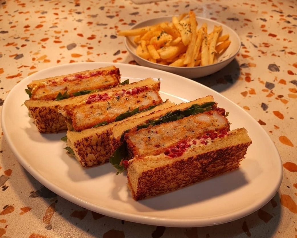 Esto’s shrimp toast features two slices of toasted brioche, a shrimp cutlet, pickled beets, Dijon mustard, mayo and housemade lemon aioli. (Photo credit: @esto_sinsa)