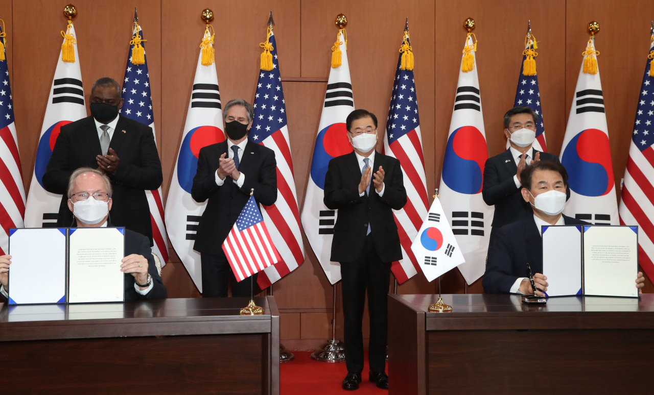 Rob Rapson (front left), acting US ambassador to Korea, and Jeong Eun-bo, Seoul’s chief negotiator for the cost-sharing talks, initial the new Special Measures Agreement over keeping 28,500 US troops in South Korea, March, 18, 2021. (Yonhap).
