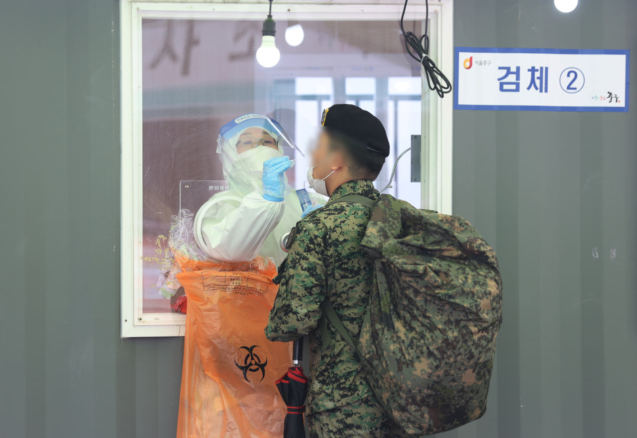 A soldier receives a test before returning to his base after vacation at an outdoor COVID-19 testing station in Seoul on March 12, 2021. (Yonhap)