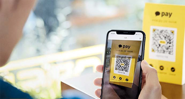 A man scans a quick response code with the Kakao Pay app. (Kakao Pay)