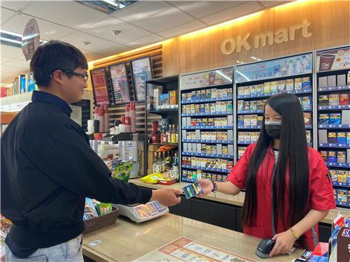 This undated file photo provided by KT&G shows a customer receiving a KT&G tobacco product from a convenience store employee in Taiwan. (KT&G)