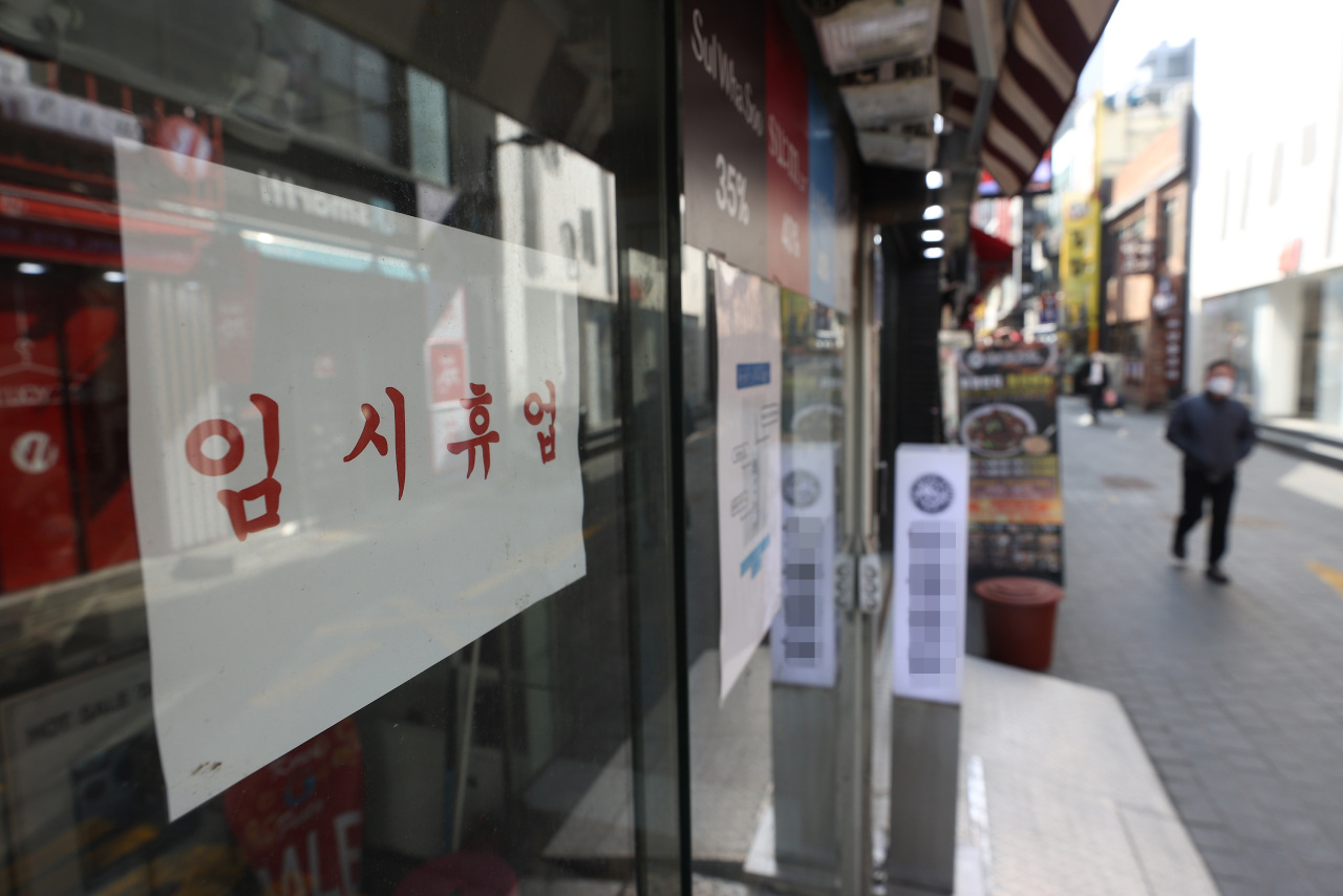 This file photo, taken March 3, 2021, shows a sign announcing a temporary closure due to the pandemic that was put up at a shop in Seoul's shopping district of Myeongdong. (Yonhap)
