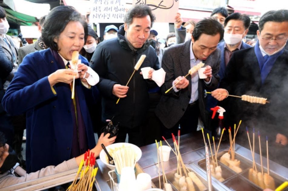 Politicians photographed eating street foods at a traditional market in Seoul on Jan. 23. From left, the Democratic Party`s Seoul mayoral candidate Park Young-sun, former chairperson Rep. Lee Nak-yon, Rep. Woo Sang-ho, and Rep. Park Sung-joon. (Yonhap)