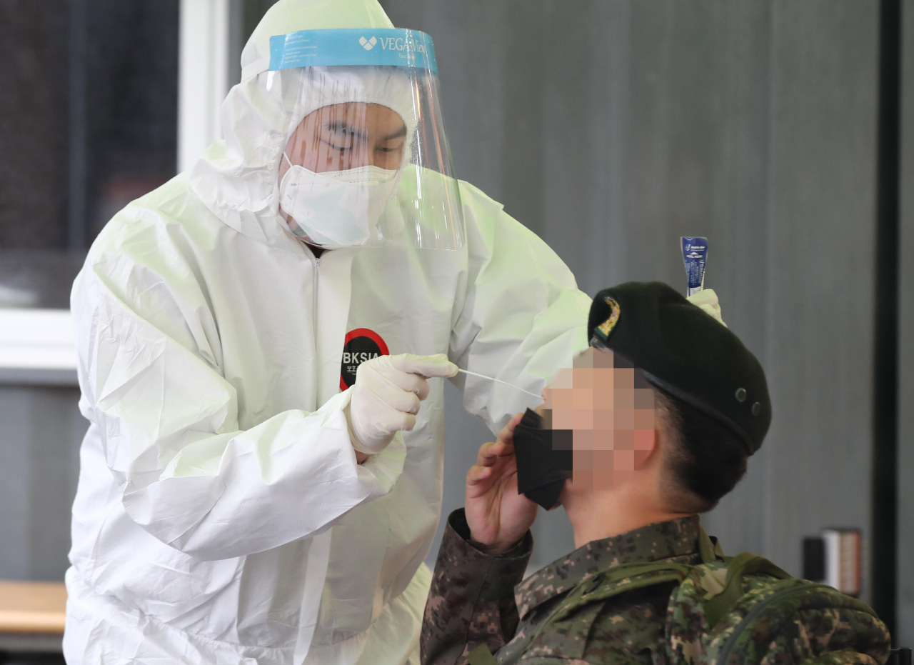 A service member undergoes a coronavirus test at a temporary COVID-19 test center at Seoul Station on March 1, 2021. (Yonhap)