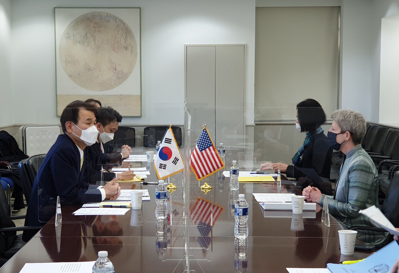 In this file photo, Jeong Eun-bo (L), South Korea's chief negotiator in defense cost-sharing talks with the United States, and his US counterpart, Donna Welton (R), engage in the latest round of negotiations in Washington on March 7, 2021, in this photo provided by the foreign ministry. (Ministry of Foreign Affairs)