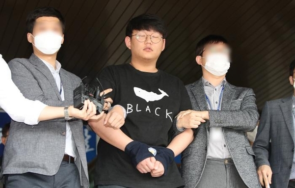 This May 18, 2020, file photo shows Moon Hyung-wook (C), a key member of a high-profile digital sexual exploitation ring, appearing before the press at the Andong Police Station in Andong, 270 kilometers southeast of Seoul. (Yonhap)
