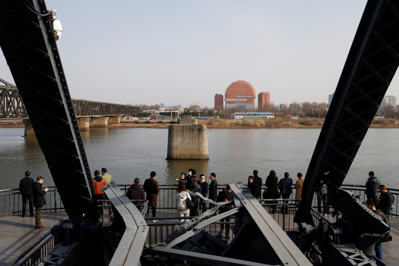 Visitors are seen on the Broken Bridge over the Yalu river which separates North Korea's Sinuiju from China, in Dandong, Liaoning province, China, on March 19. (Reuters-Yonhap)