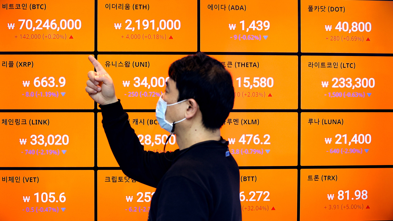 A man looks at digital boards displaying prices of digital currencies on March 30. (Yonhap)