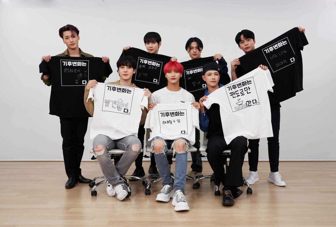 K-pop stars pose for a photo in T-shirts explaining what climate change means to them. (Climate Media Hub)