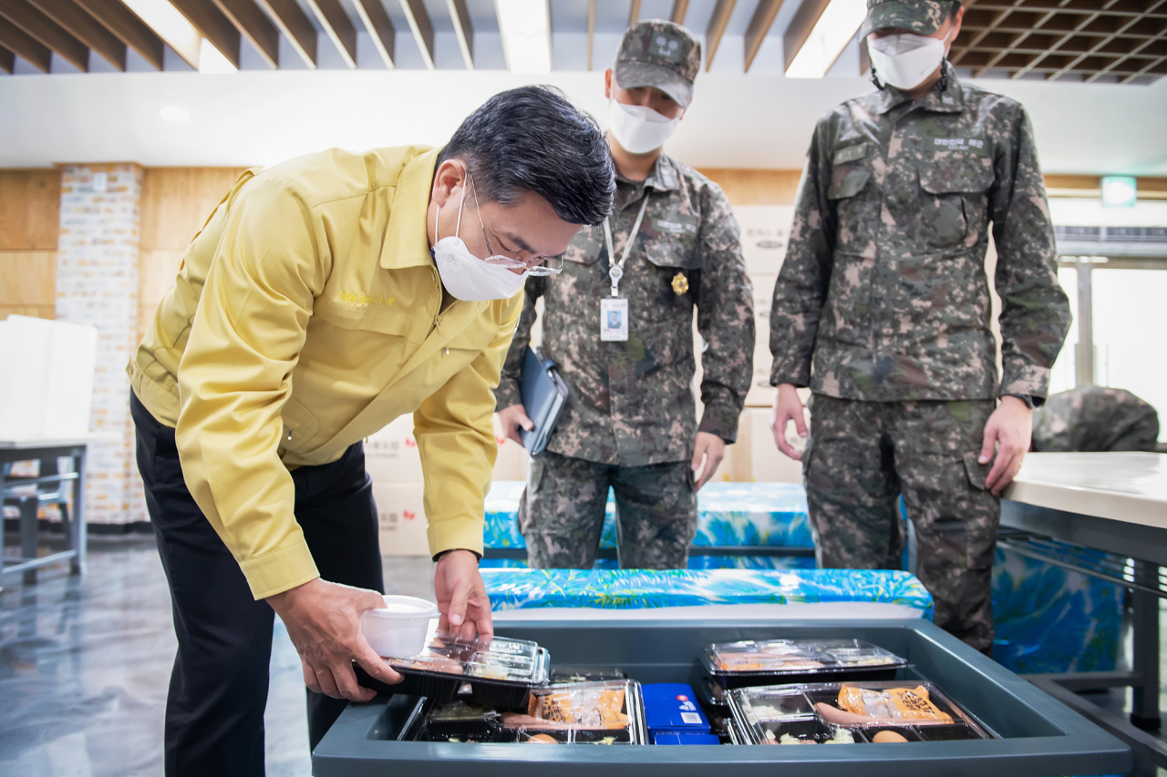 Defense Minister Suh Wook (L) checks box lunches for service members in quarantine at a naval base in Pyeongtaek, some 70 kilometers south of Seoul, on Saturday, in this photo provided by his office. (Ministry of National Defense)