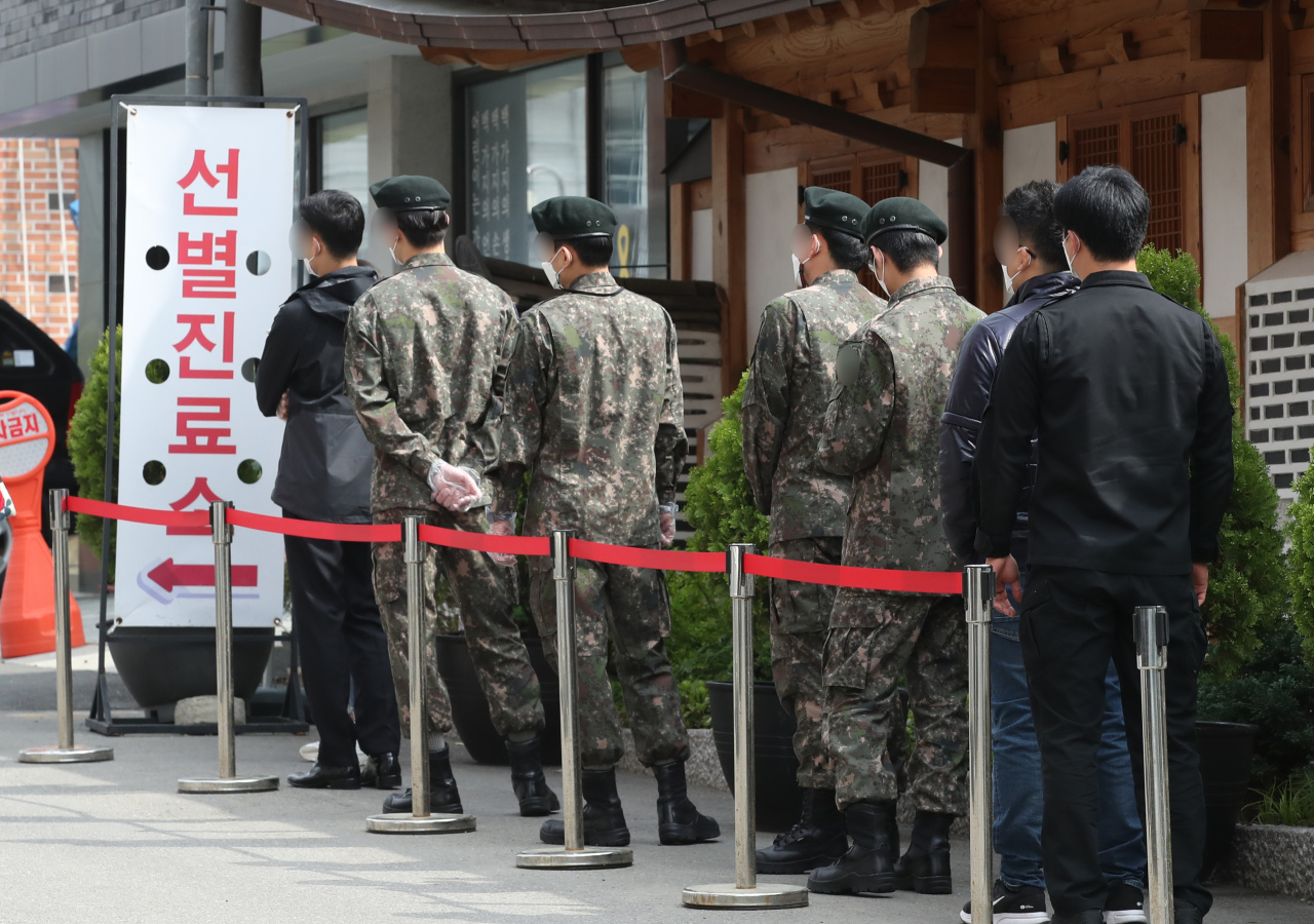 This photo shows service members in a line to receive coronavirus tests in Seoul on Monday. (Yonhap)