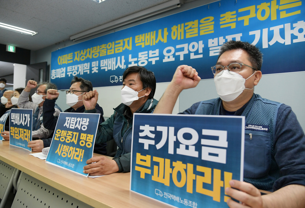 Unionized delivery workers chant slogans during a press conference Friday held to announce that the union has voted to launch a strike over an ongoing conflict with an apartment complex and its residents over a ban on ground-floor parking. (Yonhap)