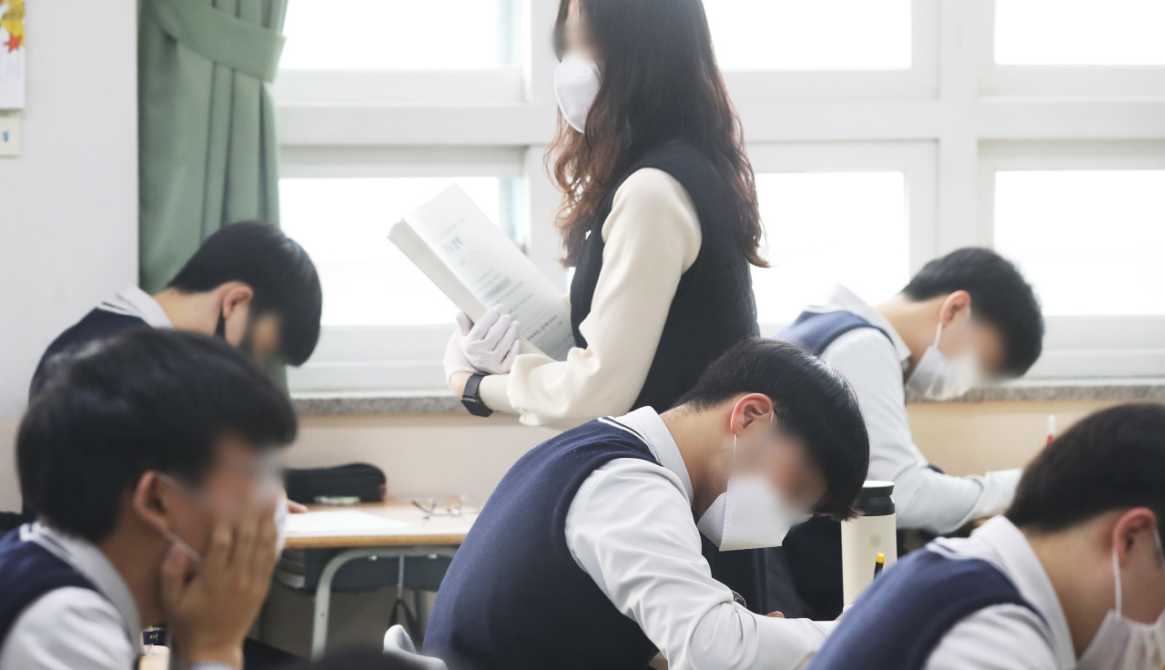 A class of students wearing masks takes this year's nationwide examination at a high school in Suwon, 46 km south of Seoul, on March 25, 2021. (Yonhap)