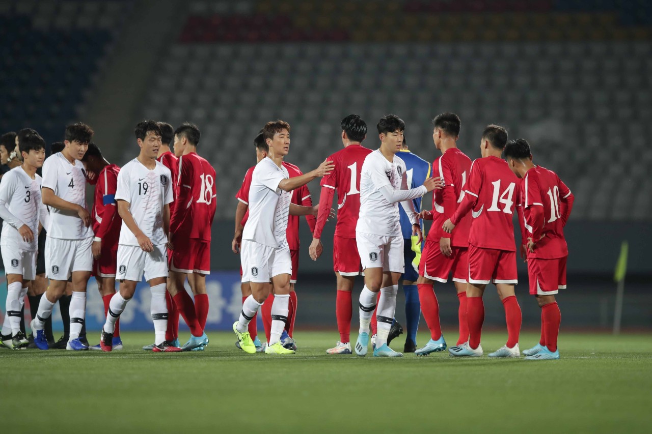 In this file photo provided by the Korea Football Association, players from South Korea (in white) and North Korea (in red) acknowledge one another after playing to a scoreless draw in a World Cup qualifying match at Kim Il-sung Stadium in Pyongyang on Oct. 15, 2019. (Korea Football Association)