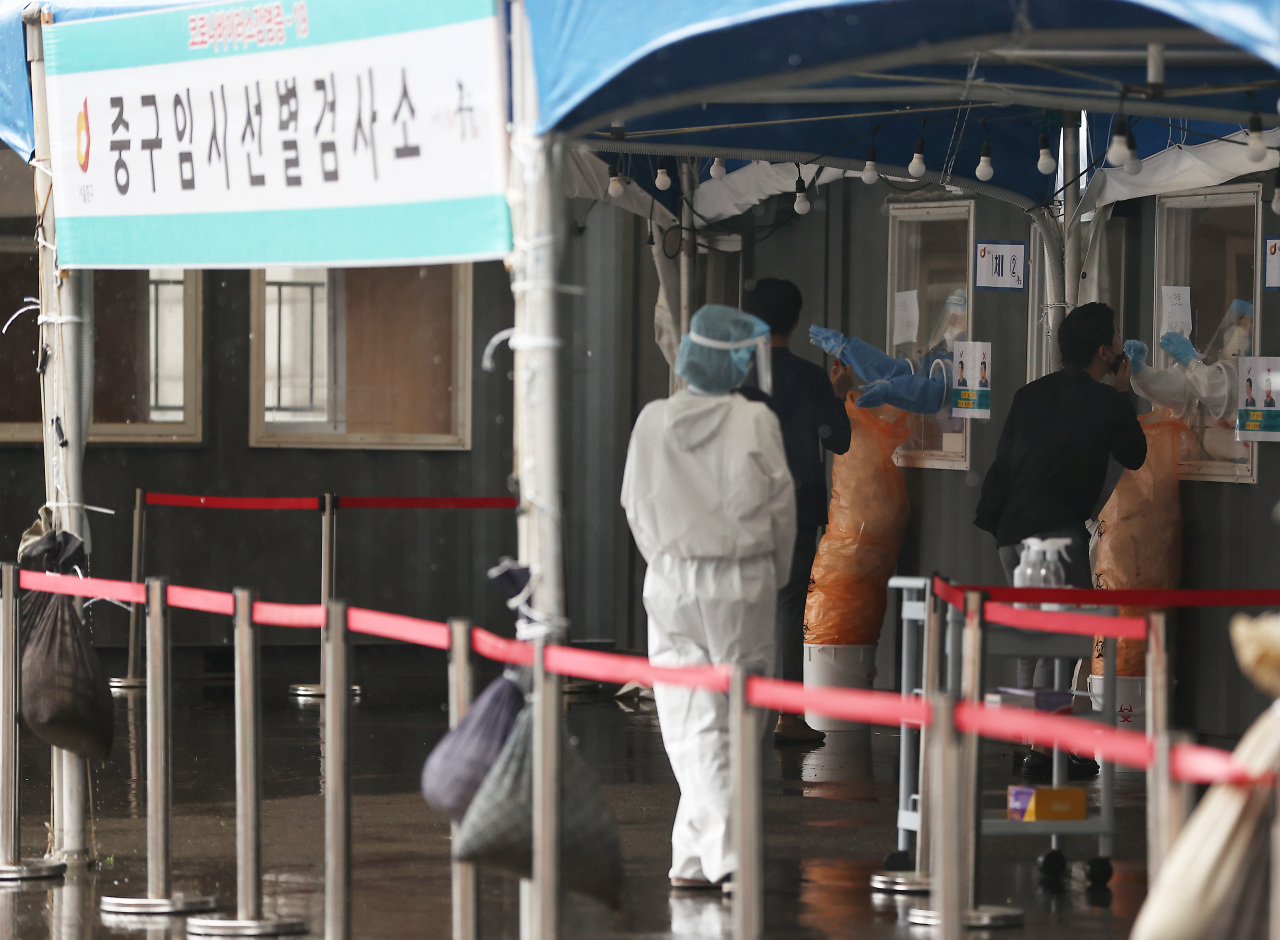 Medical workers conduct COVID-19 tests at a makeshift testing center in Seoul on Monday. (Yonhap)