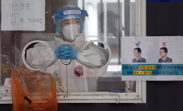 A medical worker prepares to administer a COVID-19 test at a makeshift testing center in Seoul on Tuesday. (Yonhap)