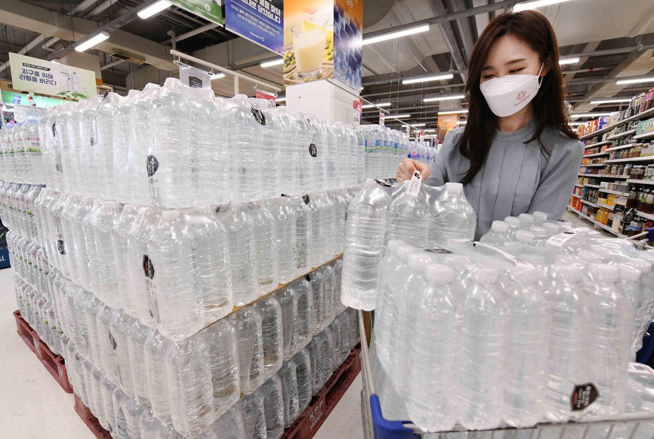 An employee at Homeplus in Gangseo-gu, western Seoul, loads label-free water bottles into a cart. (Homeplus)