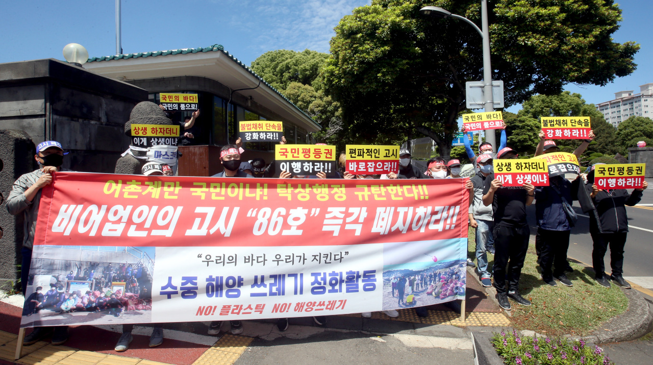 Dozens of hobbyists and leisure industry workers hold a press conference to demand the provincial government of Jeju scrap the ban on harvesting marine life at night by unlicensed people on the southern resort island of Jeju on Tuesday. (Yonhap)