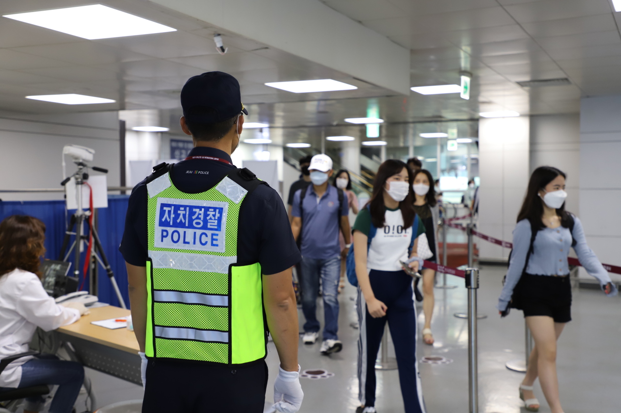 A police officer inspects tourists who have just landed at Jeju International Airport. (Jeju police website)