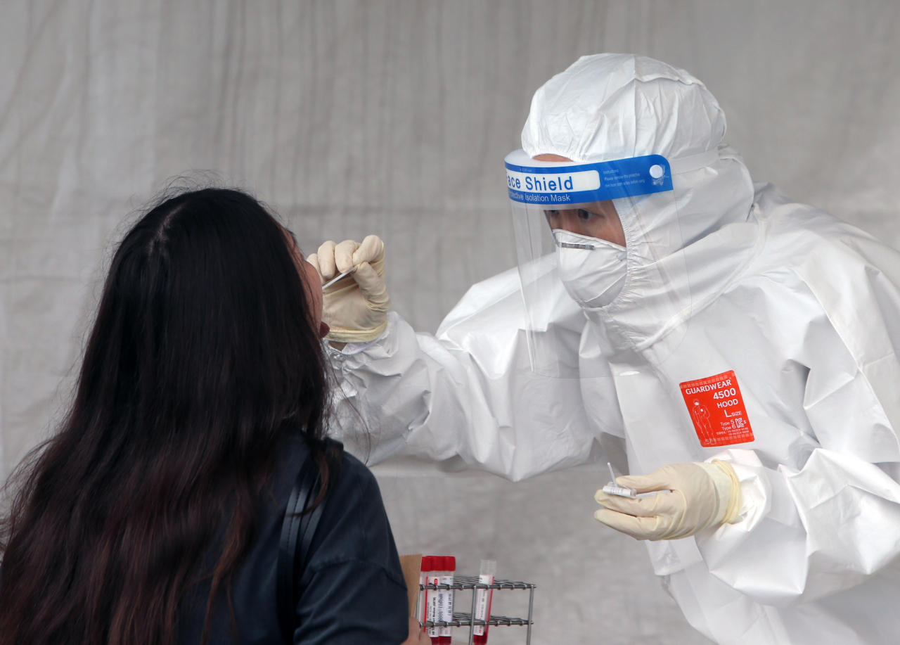 A visitor receives a COVID-19 test at a makeshift clinic in Gangneung, 237 kilometers east of Seoul, on Friday. (Yonhap)