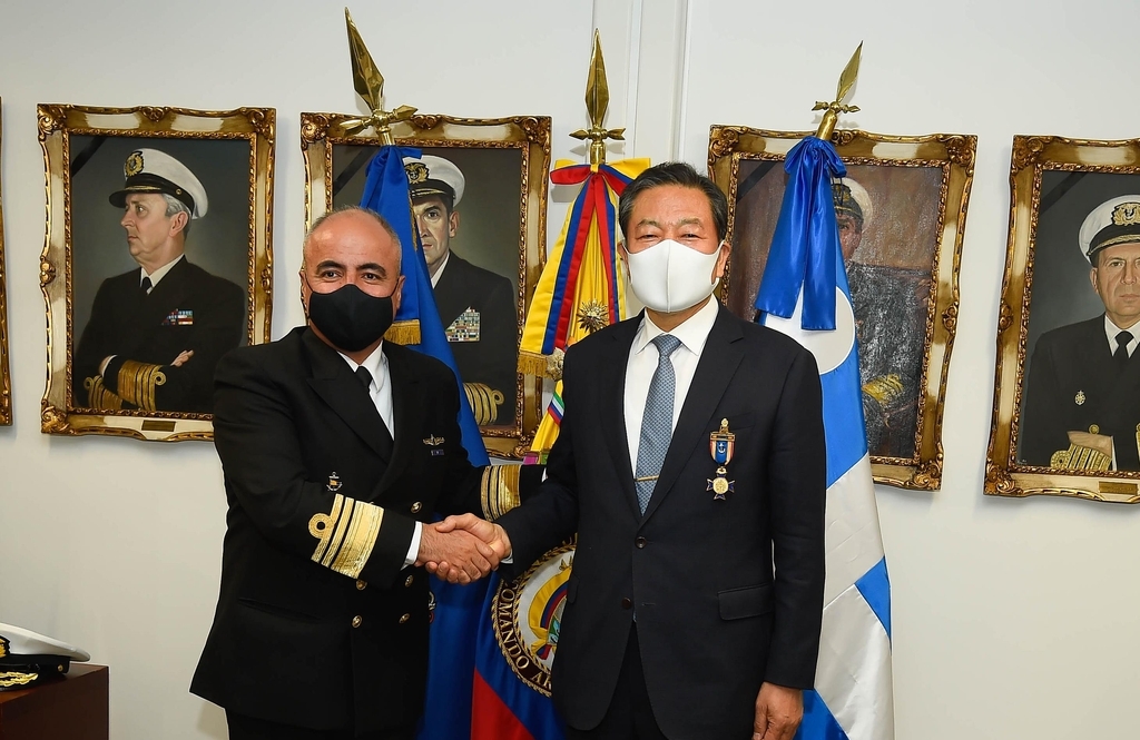 Veterans Affairs Minister Hwang Ki-chul (R) shakes hands with senior Colombian naval officer Jose Amezquita at the Latin American country's naval headquarters on Tuesday, in this photo provided by Hwang's office. (Ministry of Veterans Affairs)