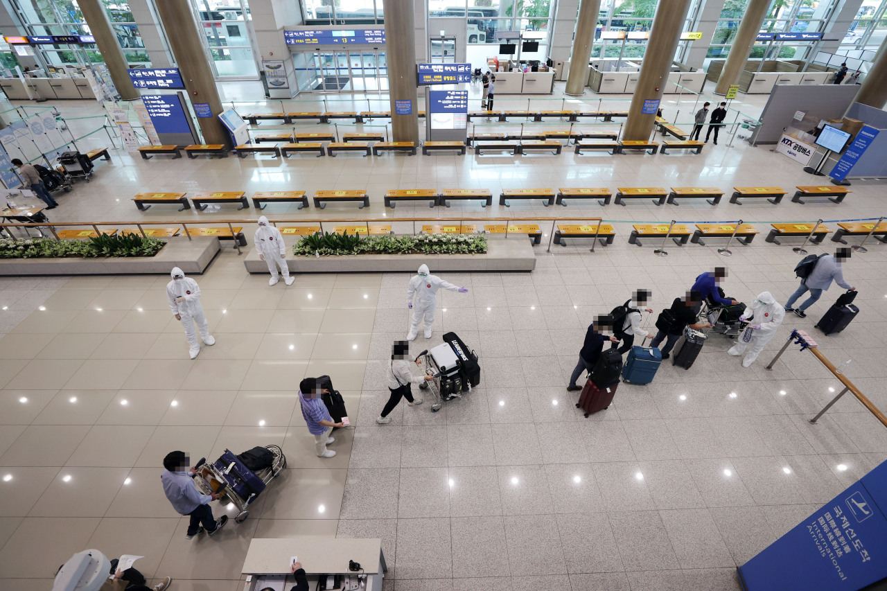 This file photo taken on May 12, 2021, shows health workers guiding arrivals from India at Incheon International Airport in Incheon. (Yonhap)