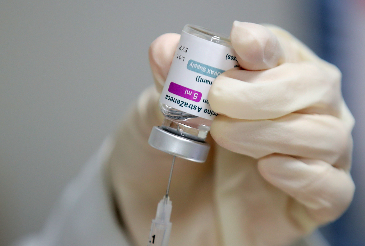 A health care worker at a Seoul public health center holds a vial of the AstraZeneca COVID-19 vaccine. (Yonhap)