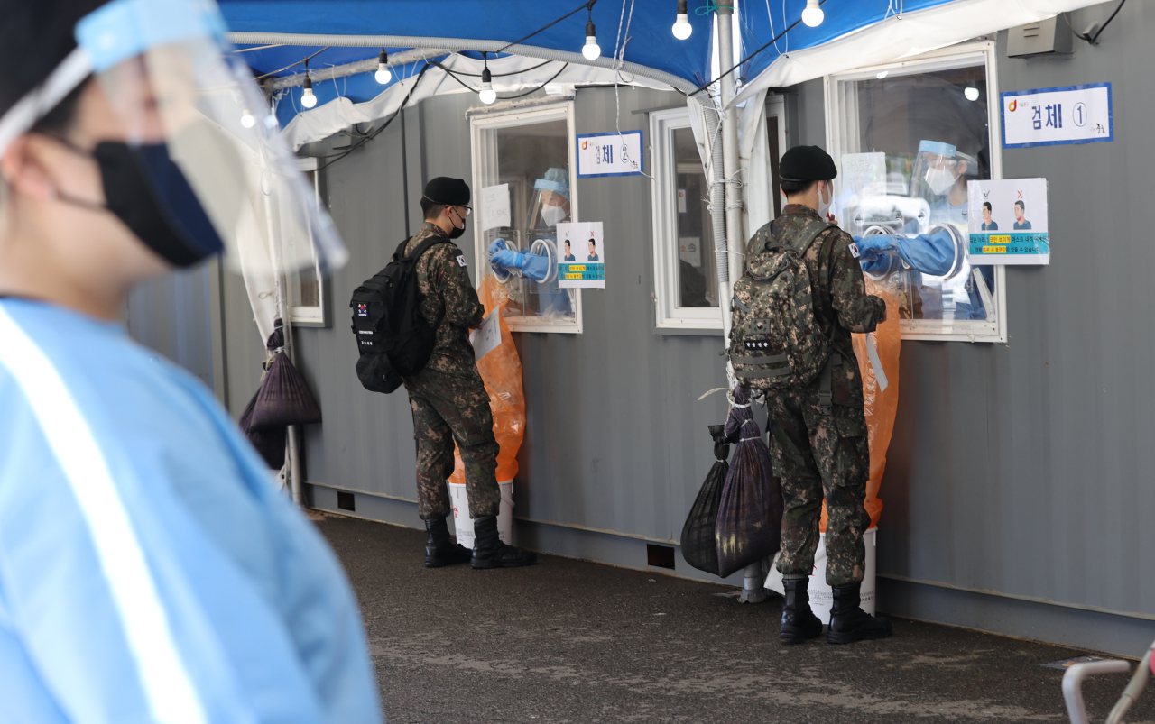 Soldiers receive COVID-19 tests at a makeshift clinic in central Seoul on Wednesday. (Yonhap)