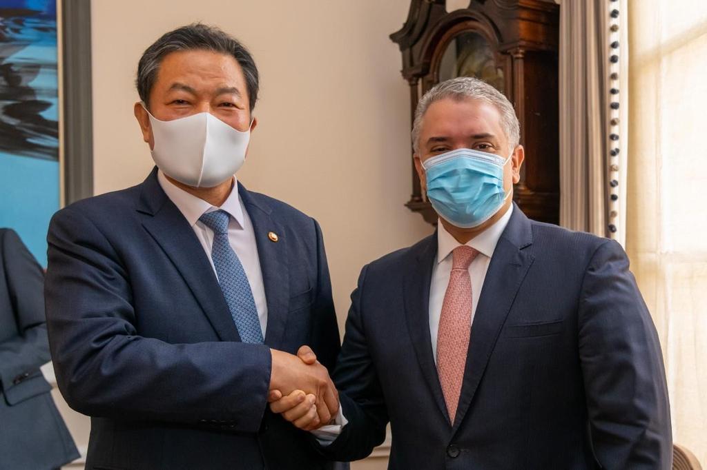 Veterans Affairs Minister Hwang Ki-chul (L) shakes hands with Colombian President Ivan Duque in the Latin American country on Tuesday, in this photo provided by the Colombian presidential office. (Colombian presidential office)