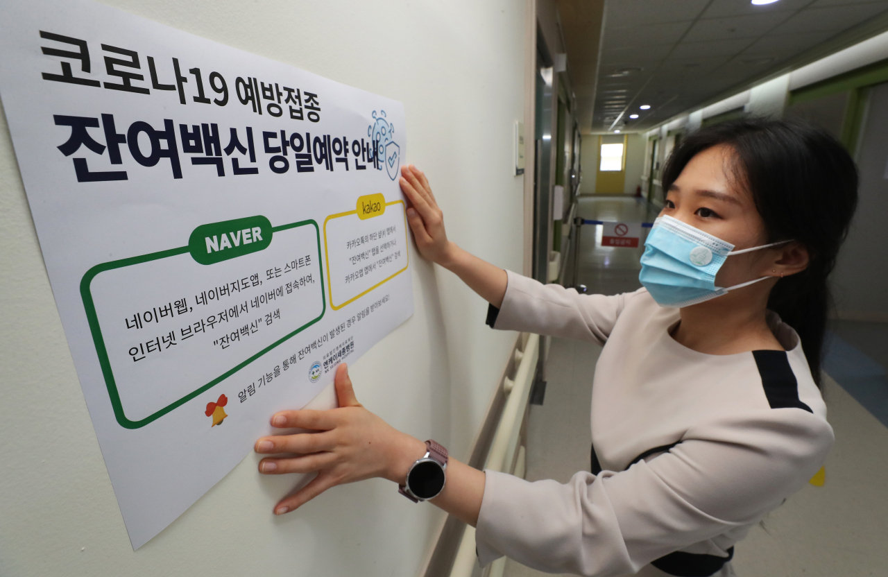 A medical worker posts instructions on applying for leftover COVID-19 shots through popular mobile platforms, such as Naver and Kakao, at a hospital in the central city of Sejong on Thursday. (Yonhap)