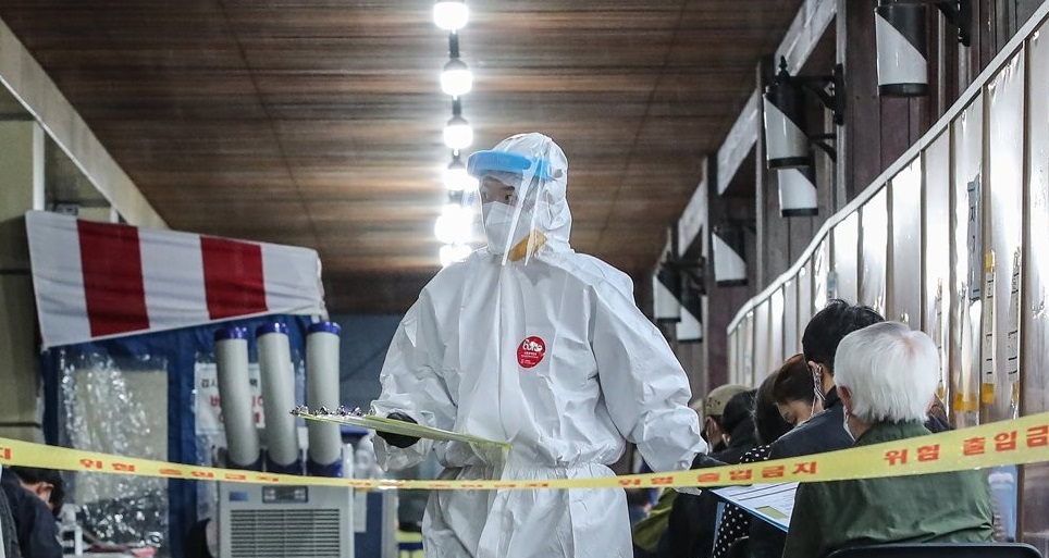 A health worker in a protective suit works at a makeshift virus testing clinic in Seoul on Friday. (Yonhap)