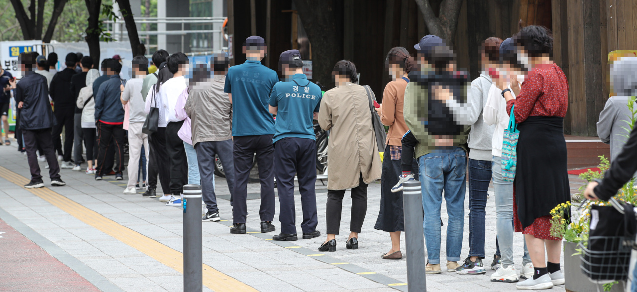 Citizens line up to take COVID-19 tests on Saturday, at a screening center set up in a public health center in Songpa Ward, Seoul. (Yonhap)