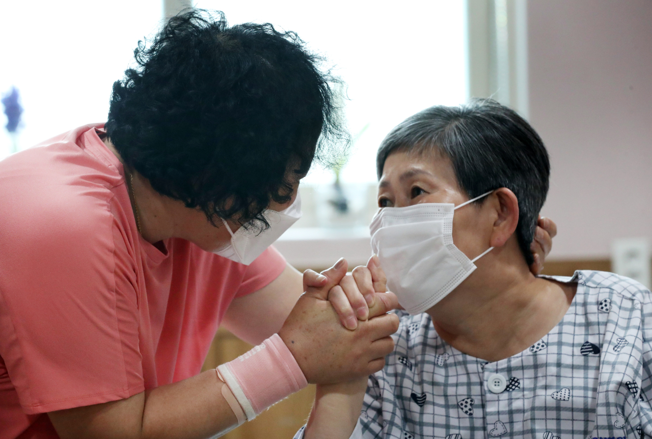 Mother and daughter reunite Tuesday at care center in Daejeon after reopening of nursing homes and hospitals nationwide. (Yonhap)