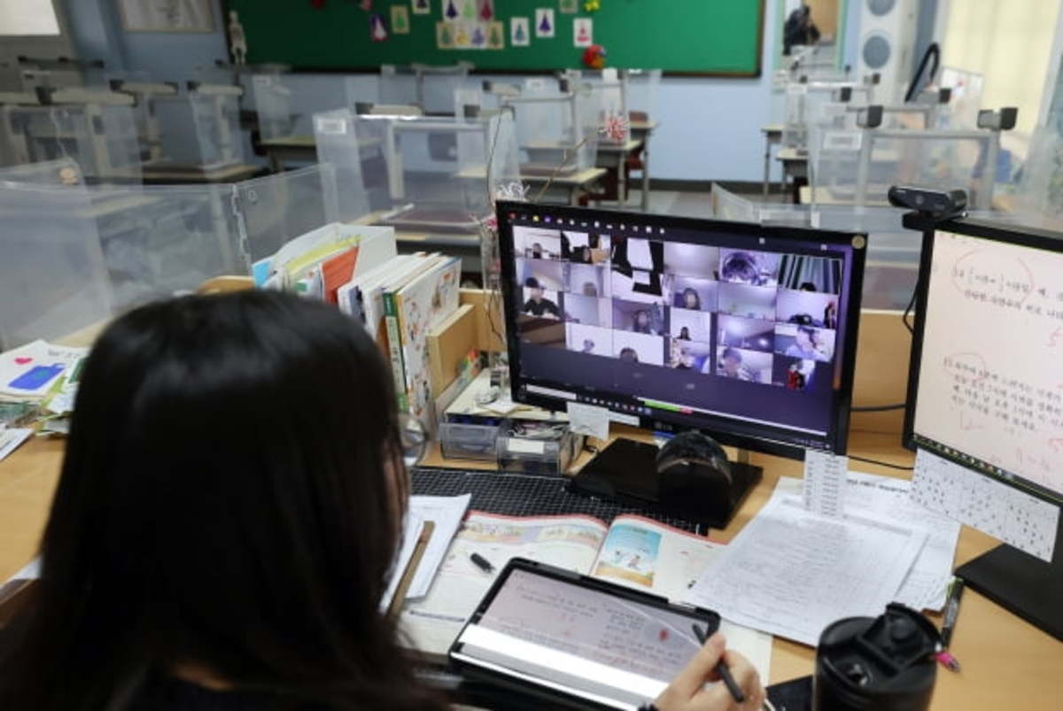 A teacher talks with students during an online class in an elementary school in Seoul on Jan. 28, 2021. (Yonhap)