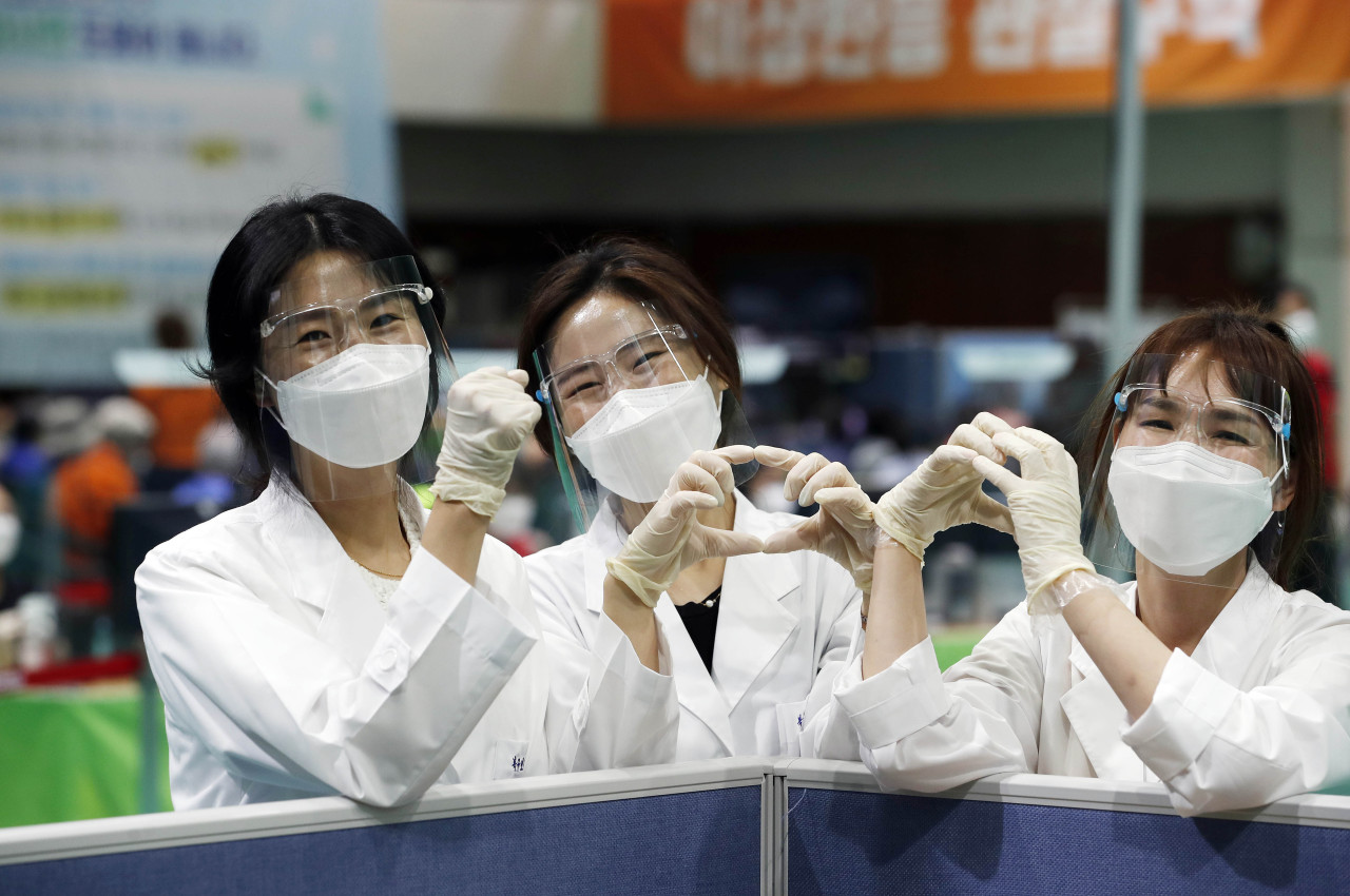 Health care workers at a vaccination clinic in Gwangju gesture the number 100 on Friday. Saturday marks 100 days since Korea administered the very first COVID-19 vaccine doses in the country. (Yonhap)