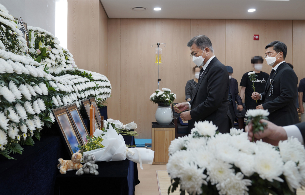 This photo provided by Cheong Wa Dae shows President Moon Jae-in (L) paying tribute to a deceased noncommissioned female officer at a funeral home in Seongnam, just south of Seoul, on Sunday. The officer apparently committed suicide after being victimized in a military sexual harassment case and forced to remain silent by her seniors. (Cheong Wa Dae)