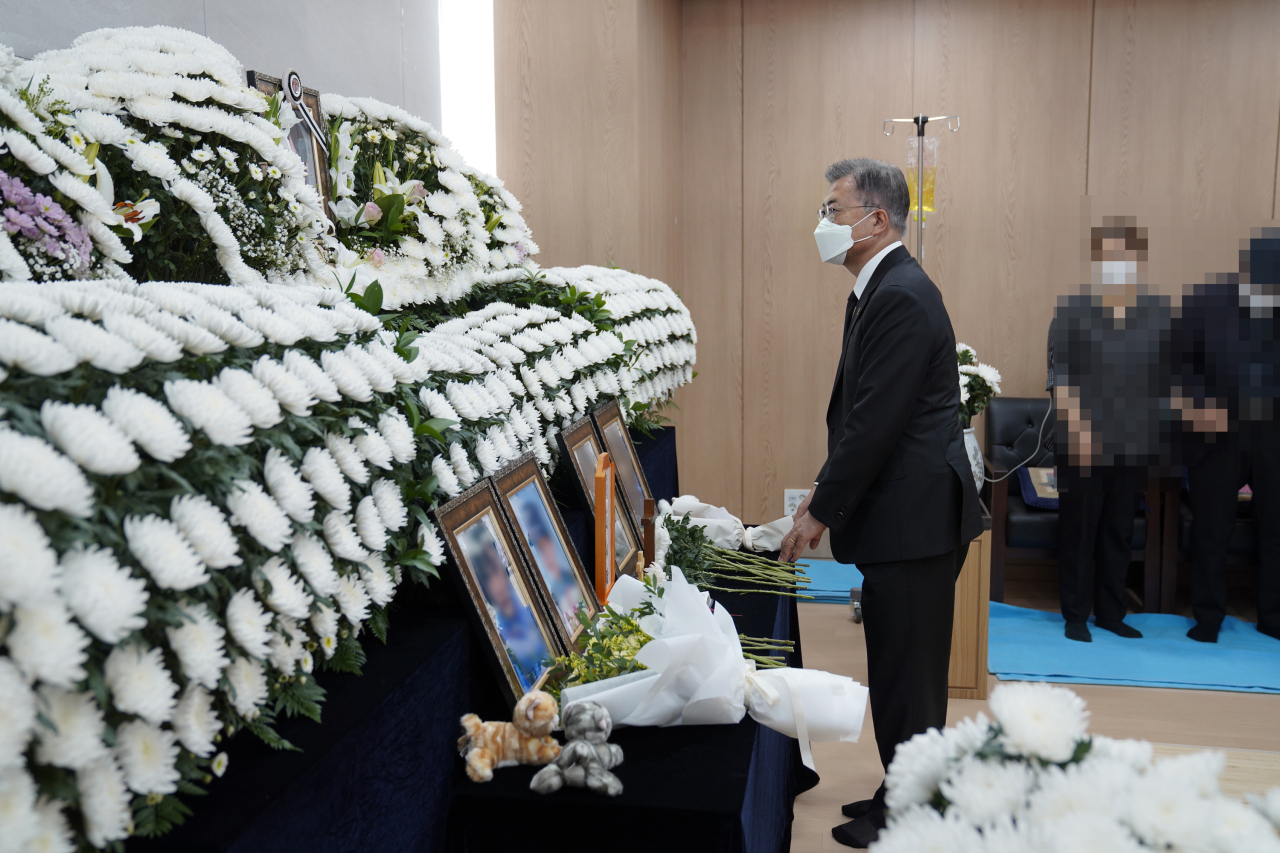 In this photo provided by Cheong Wa Dae, President Moon Jae-in pays silent tribute to a late female Air Force noncommissioned officer at a funeral home of Armed Forces Capital Hospital in Seongnam, just south of Seoul, on Sunday. (Cheong Wa Dae)