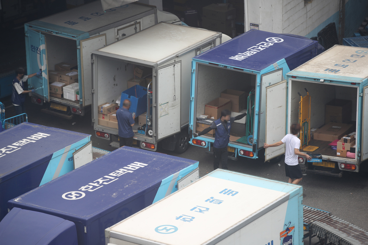 Couriers prepare to head out from a distribution center in Seoul to deliver parcels on Monday. (Yonhap)