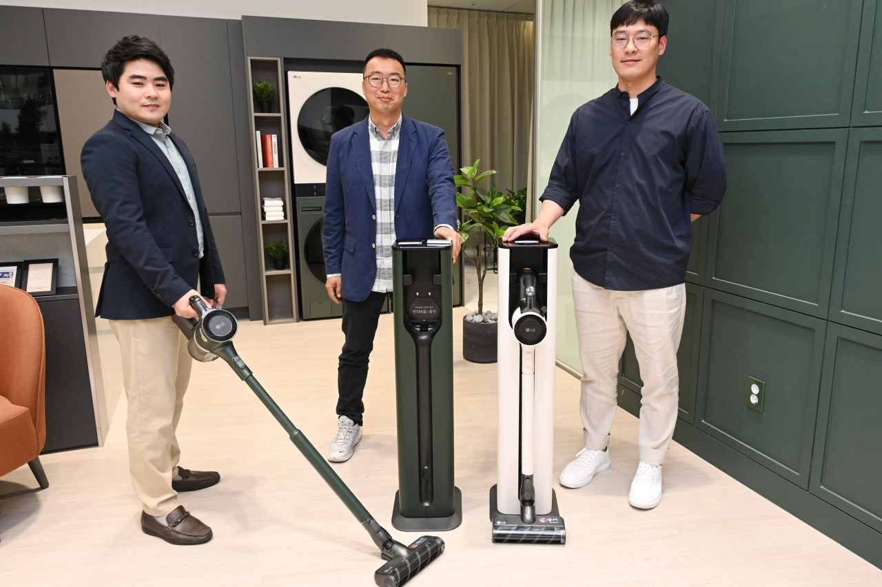 From left: Song Ki-yong, Yoo Byung-do and Moon Si-hwan of LG Electronics pose with the LG CordZero A9 Kompressor+ docked in the All-in-one Tower at the LG Best Shop in Yeouido, western Seoul. (LG Electronics)