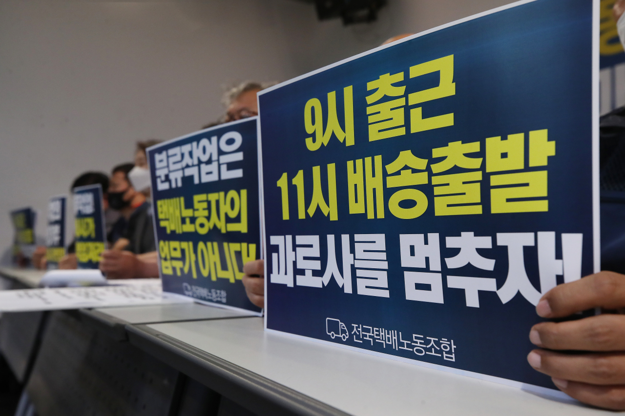 This file photo shows officials from the Parcel Delivery Workers' Solidarity Union holding signs announcing their planned collective action during a news conference held in central Seoul on Friday. (Yonhap)