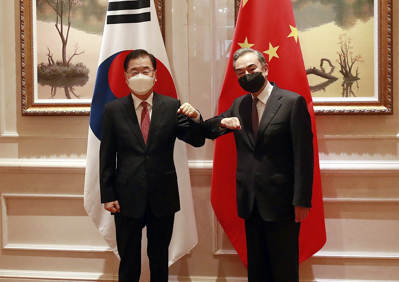 This photo, taken on April 3, 2021, shows Foreign Minister Chung Eui-yong (L) and his Chinese counterpart, Wang Yi, bumping elbows before their talks in the southeastern city of Xiamen. (Yonhap)