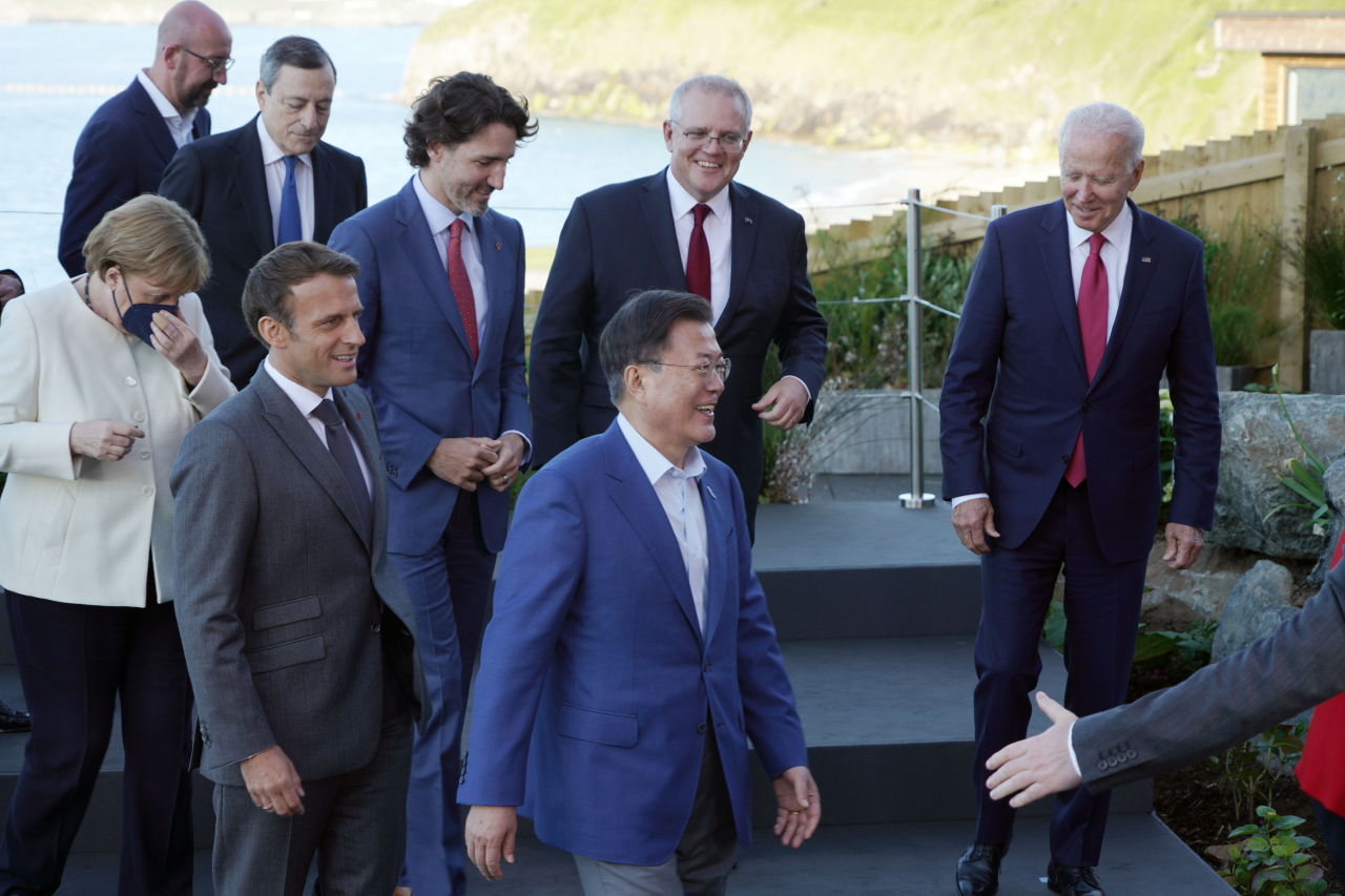 President Moon Jae-in (center) walks off after posing for photos with G-7 members in Cornwall, England, on Saturday. (Yonhap)
