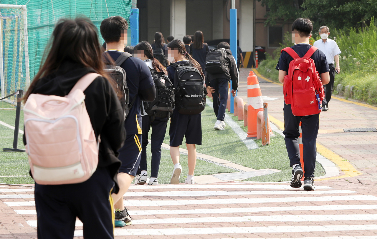 Middle school students go to school in Seoul on Monday. (Yonhap)