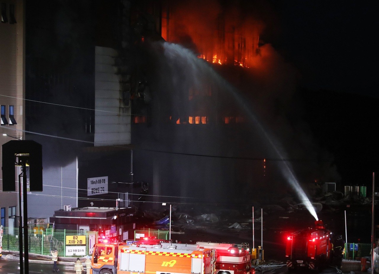 Firefighters try to put out a fire at a Coupang distribution center in Icheon, some 80 kilometers south of Seoul, on Thursday. (Yonhap)